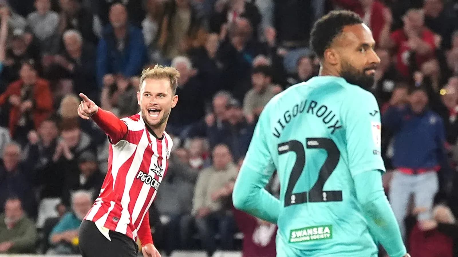 Player celebrating a goal while opponent looks on