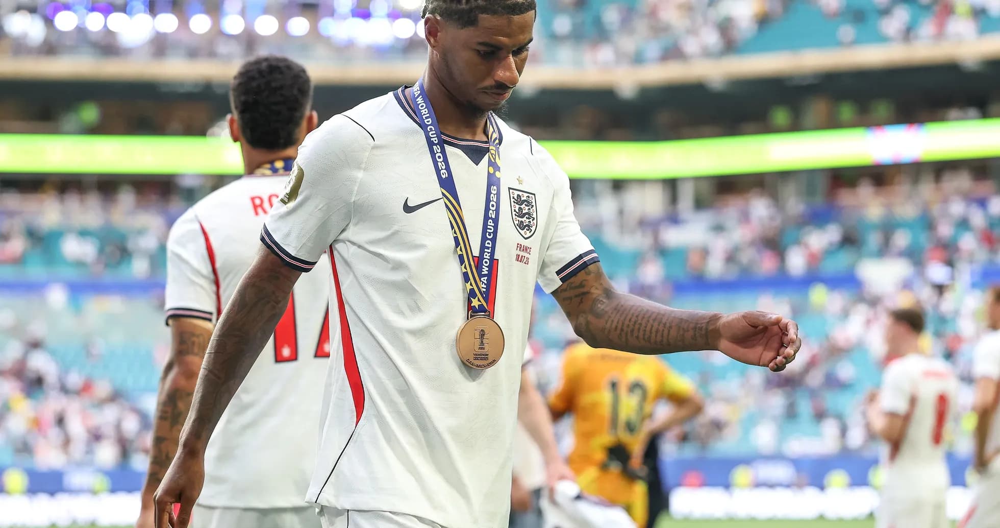 Player walking off field wearing medal after match