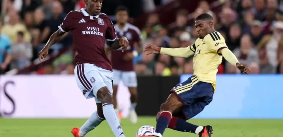 Aston Villa player tackling Arsenal player during match