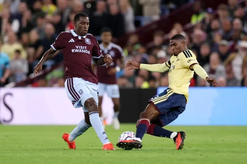 Aston Villa player tackling Arsenal player during match