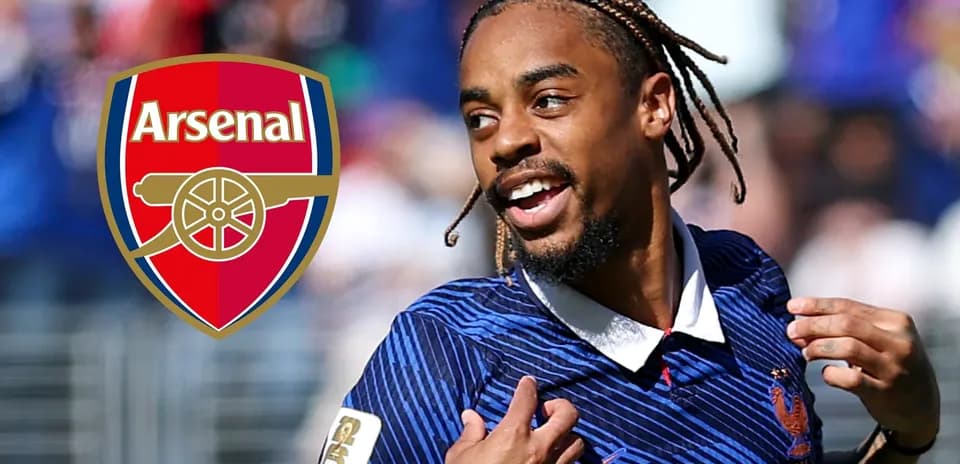 Futbolçu Arsenal loqosunun önündə gülərək