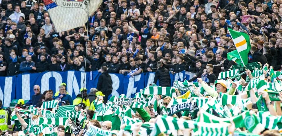 Fans waving scarves during football match celebration