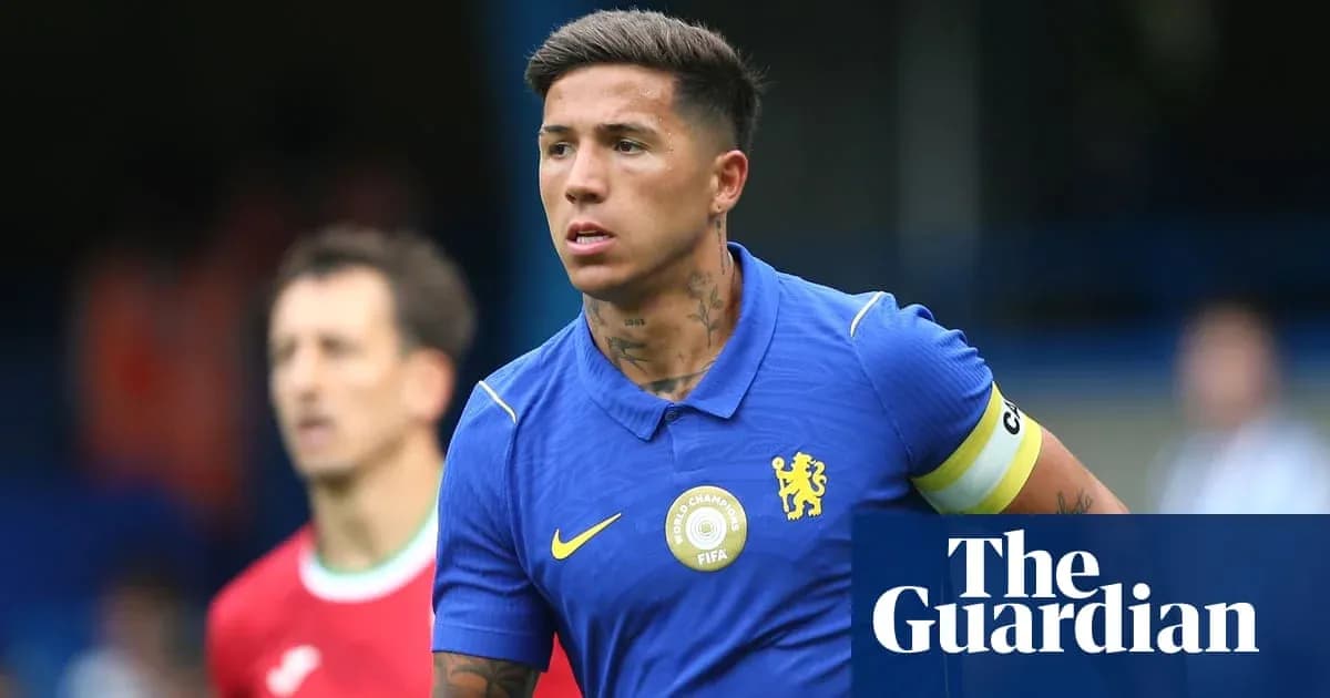 Futbolçu mavi forma ilə meydanda yürüyür