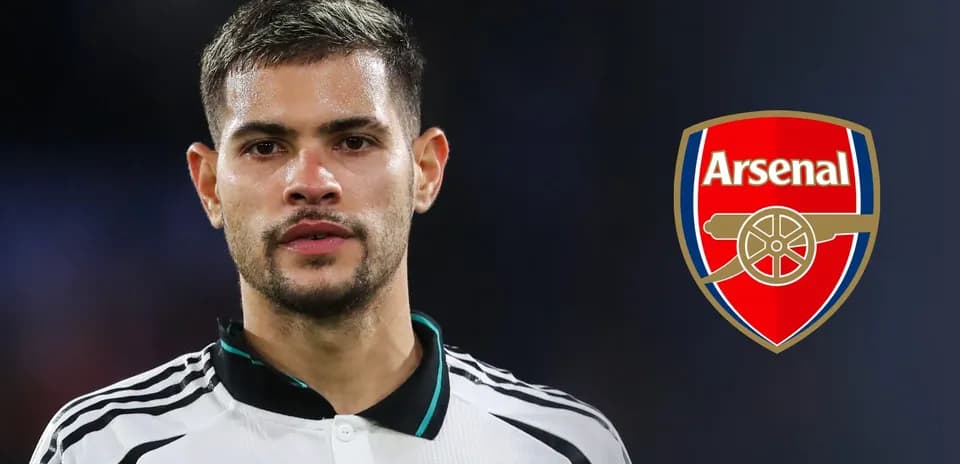 Futbolçu Arsenal loqosunun yanında durur