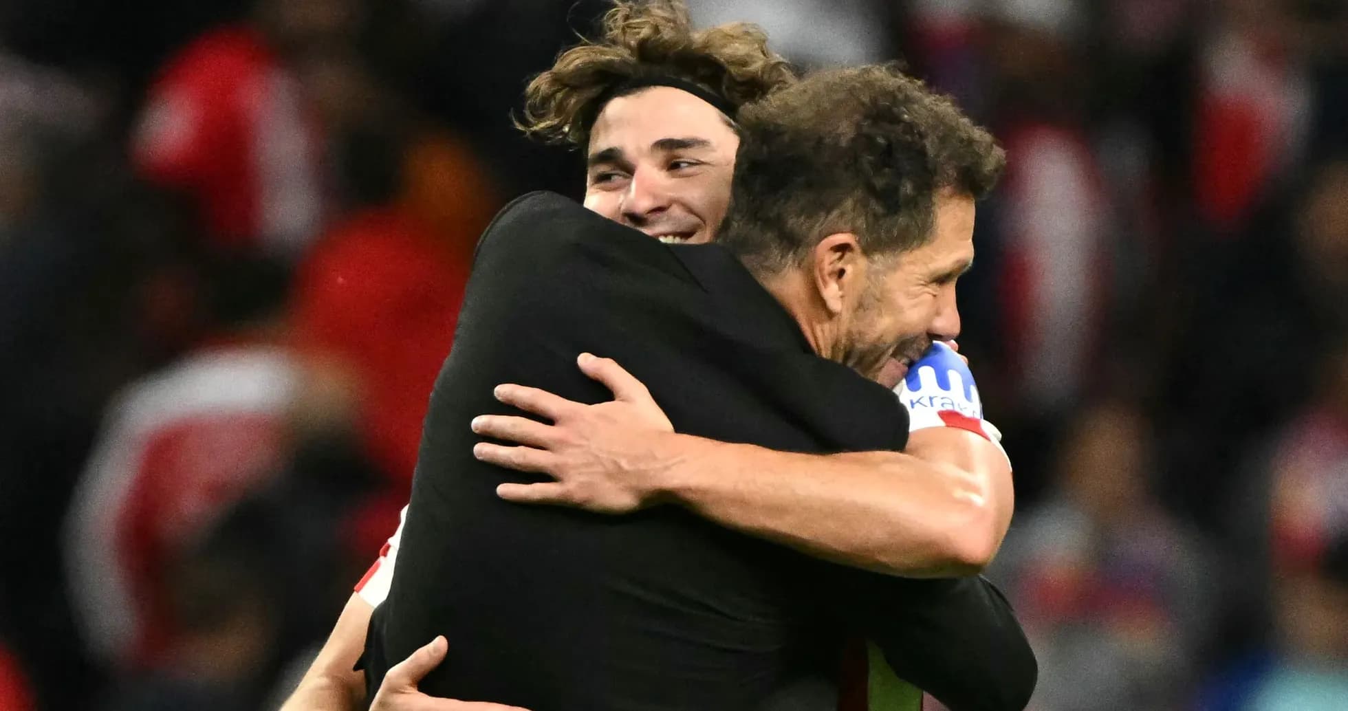 Player and coach embracing after a match victory