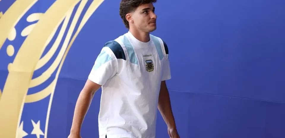 Futbolçu mavi divar arxasında yürüyür