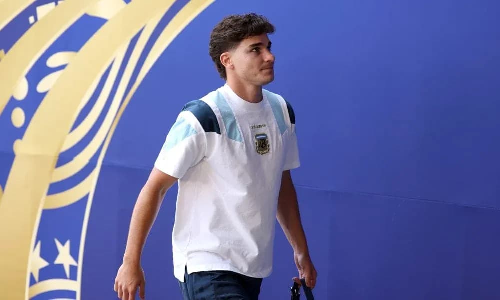 Futbolçu mavi divar arxasında yürüyür