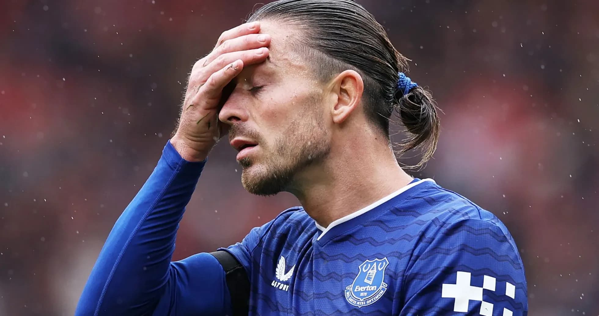 Futbolçu Everton formasında başını tutaraq durur
