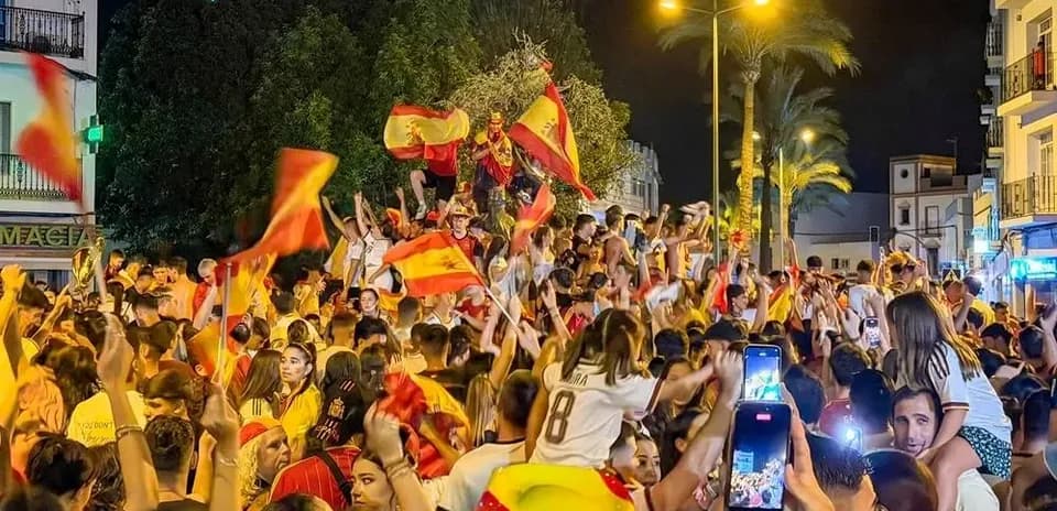 Fans celebrating with flags in street at night