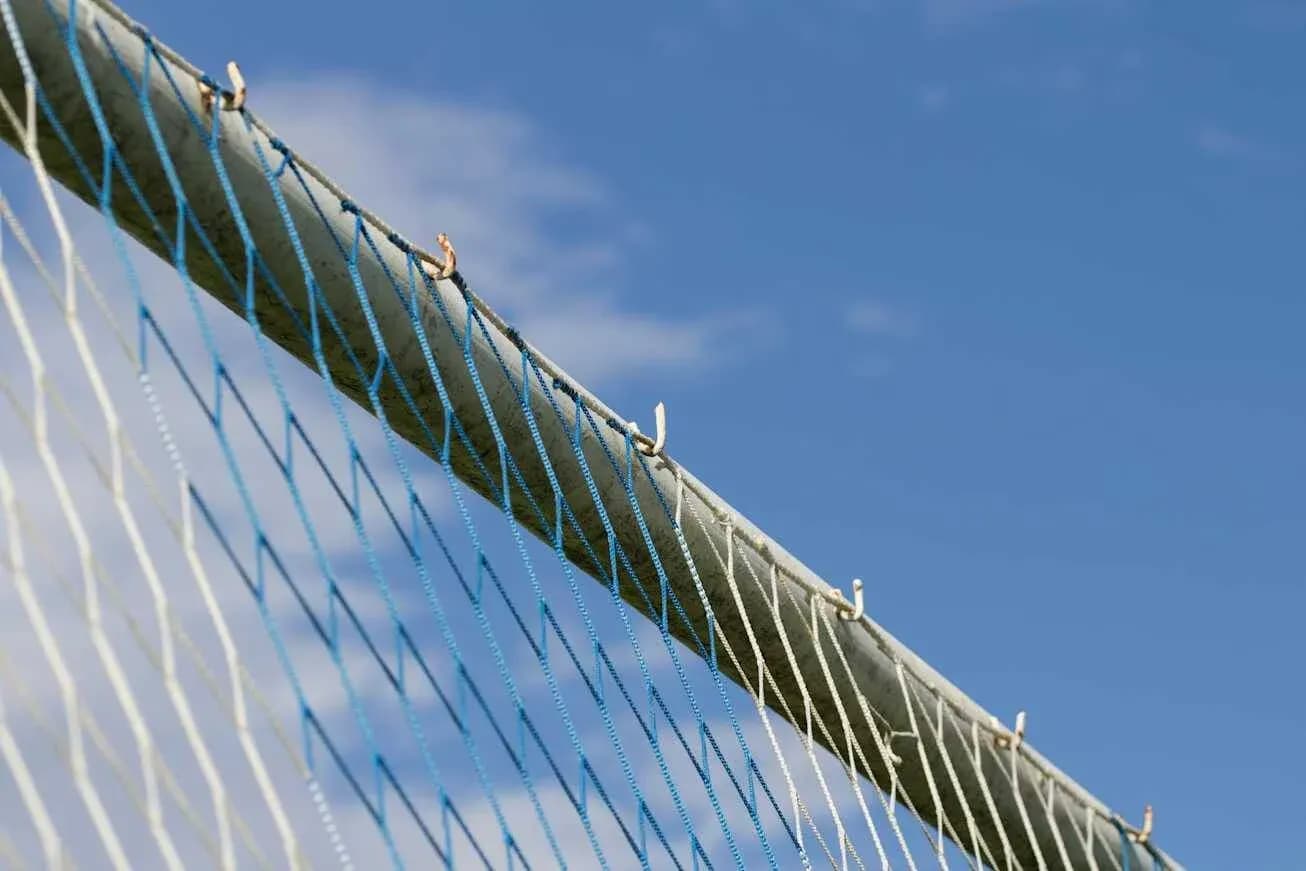 Close-up of goal net against blue sky