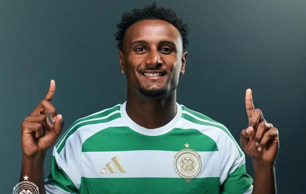 Futbolçu forma geyinərək bir əlini qaldırır