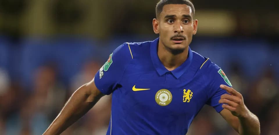 Futbolçu mavi forma ilə topa yönəlir