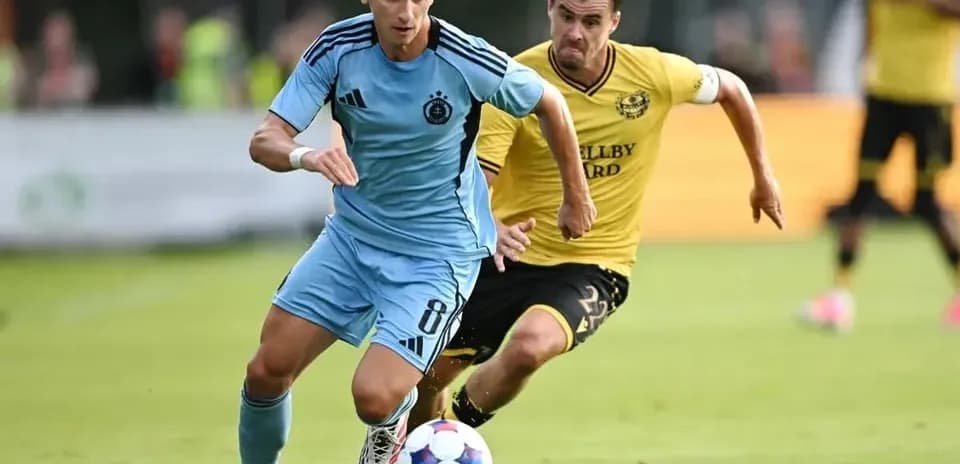 Slovan Bratislava futbolçusu topu irəliləyir