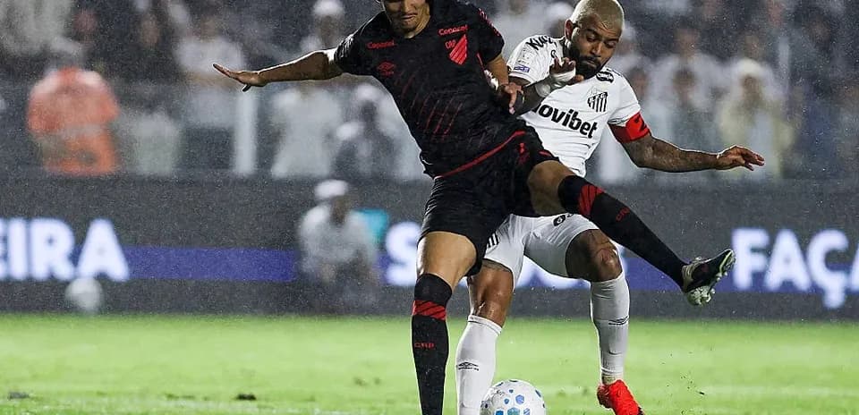 Two players competing for the ball in rain