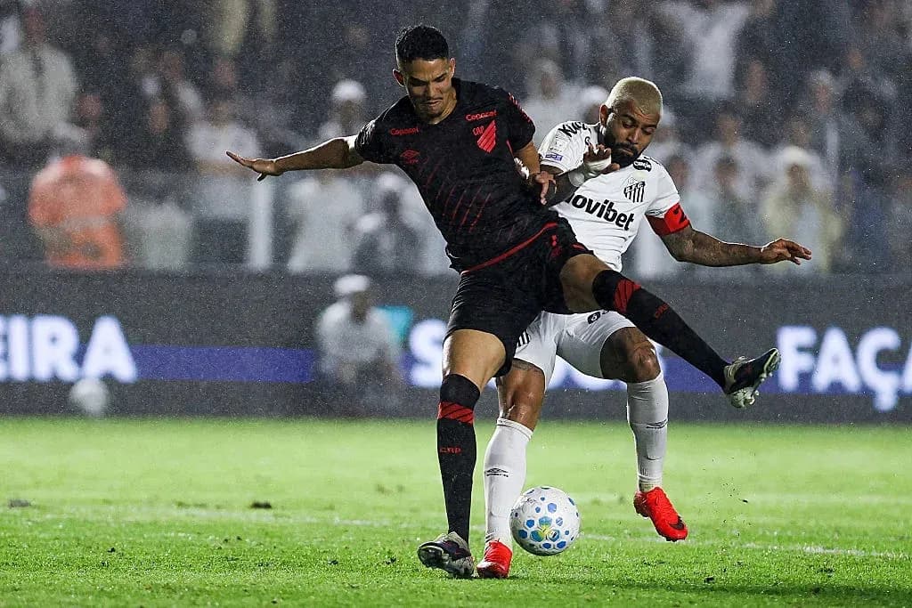 Two players competing for the ball in rain