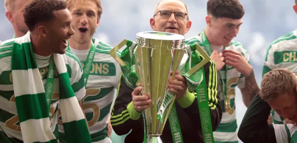 Celtic players celebrating with trophy after victory