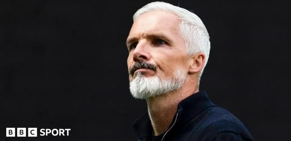 Coach with white hair and beard during press conference