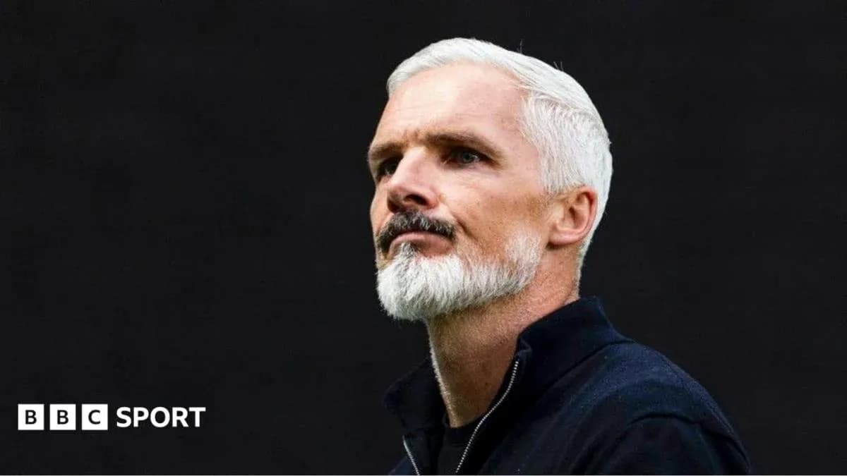 Coach with white hair and beard during press conference