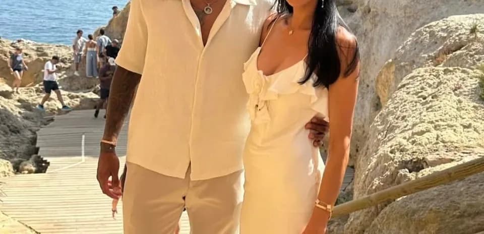 Pair posing together near rocky coastline