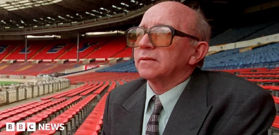 Man wearing glasses seated in empty stadium