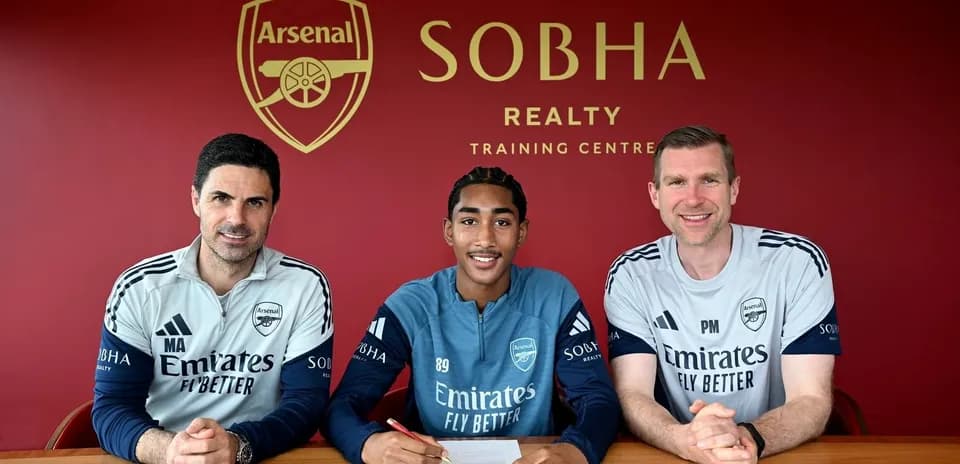 Arsenal player signing contract with coaches at training center