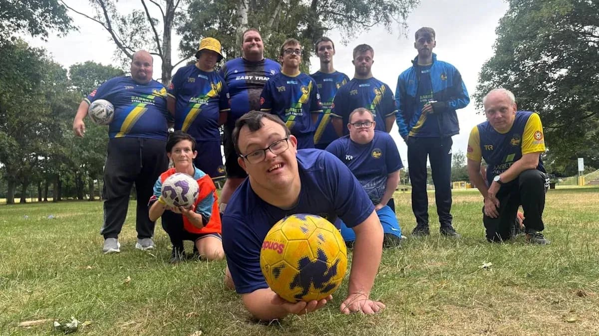 Soccer team posing with balls in park