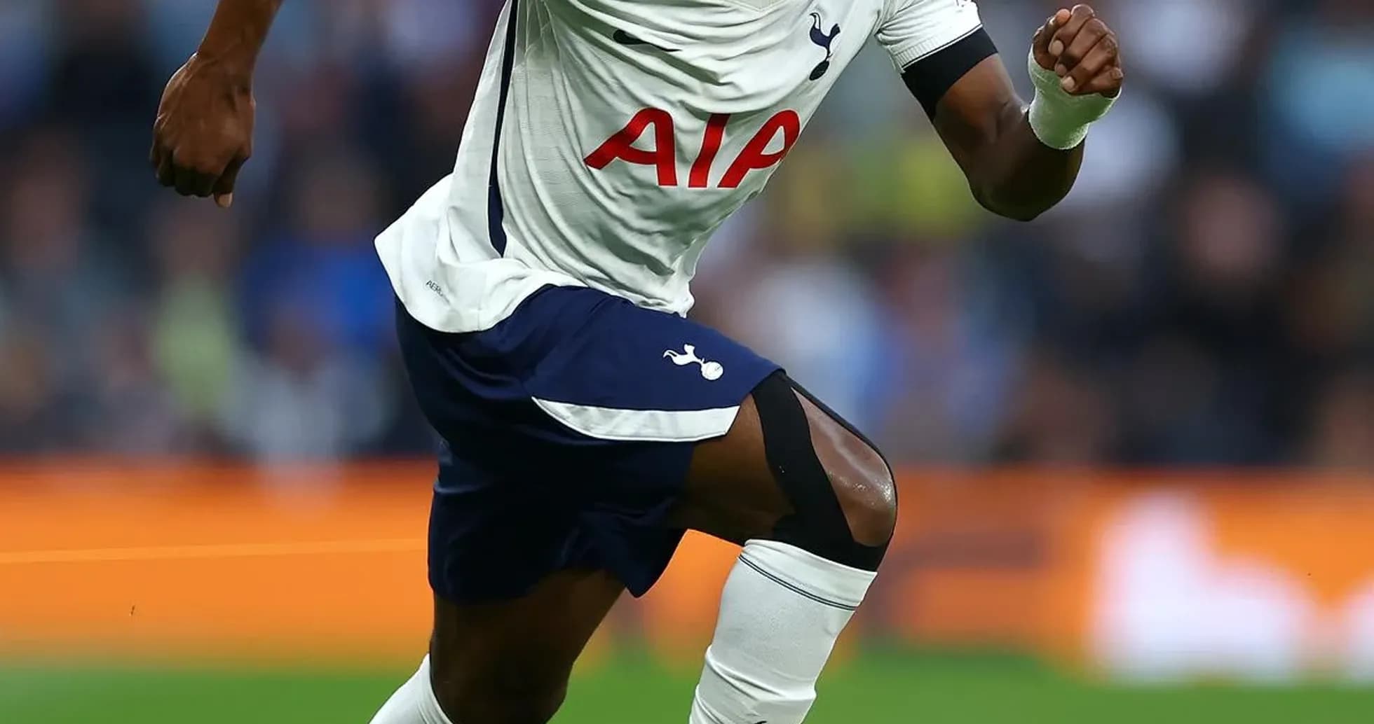 Tottenham player sprinting towards the ball on pitch
