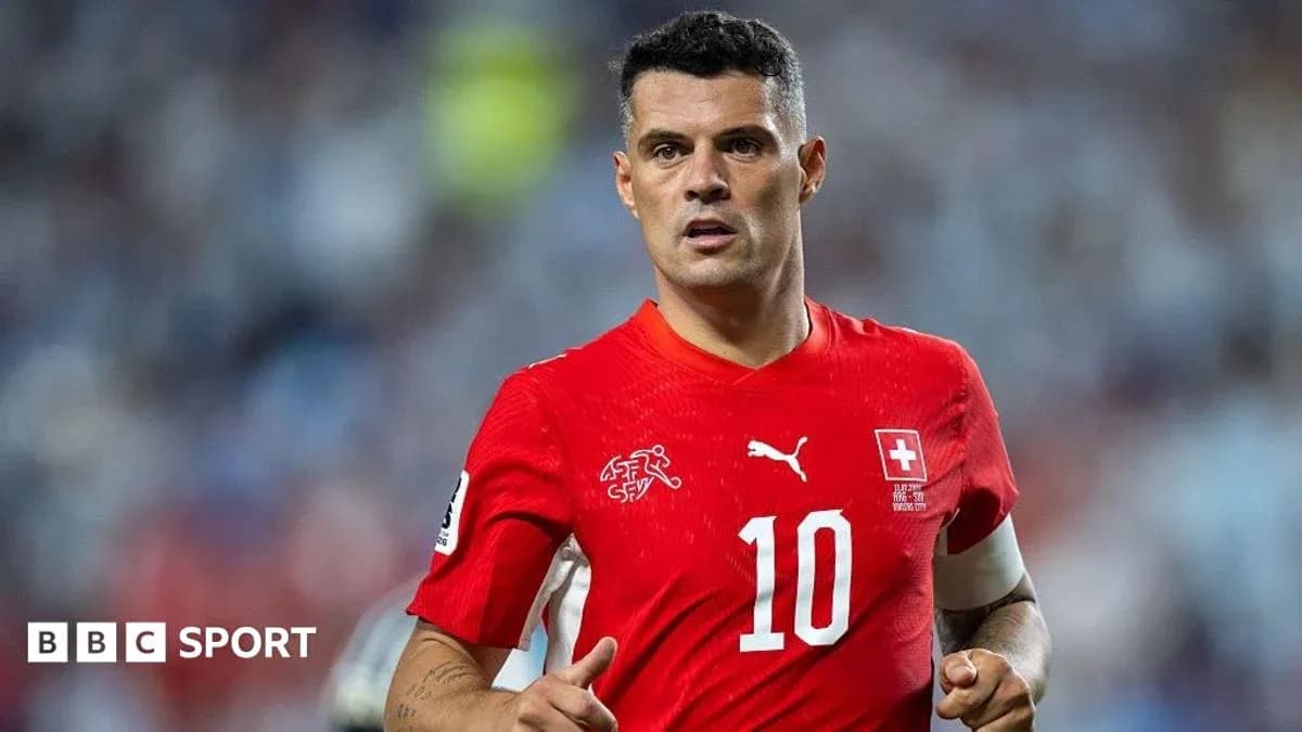 Futbolçu qırmızı forma ilə meydanda yürüyür