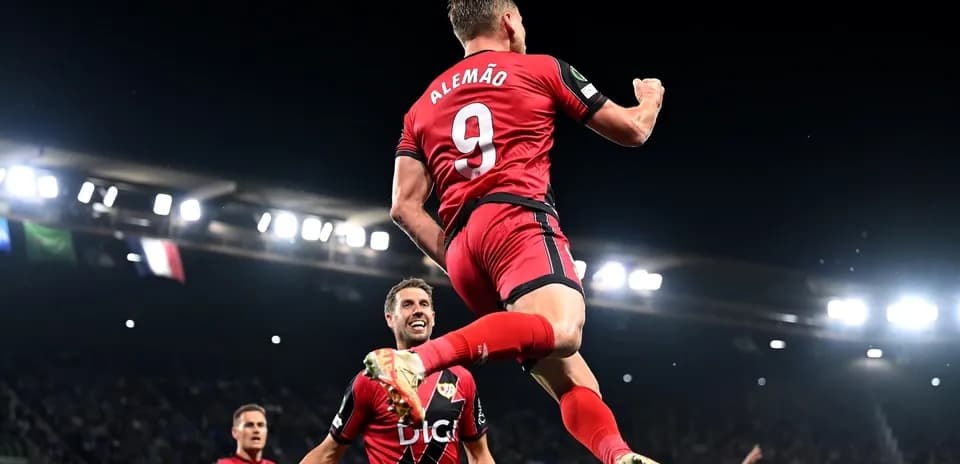 Player celebrating a goal with teammates in match