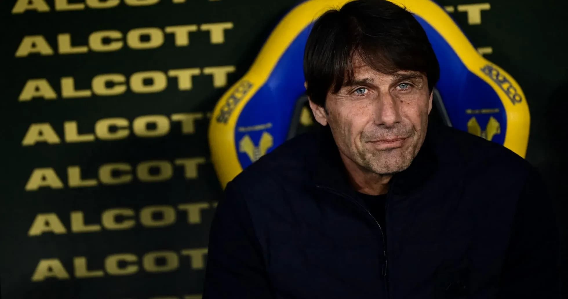 Coach seated on bench during match preparations