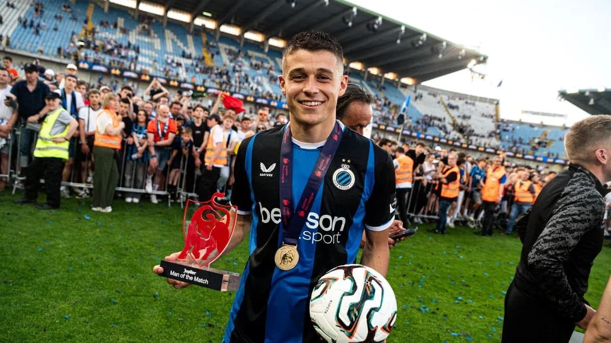 Player celebrating with trophy and fans in stadium
