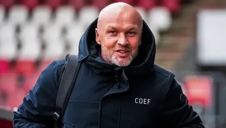 Coach arriving at stadium in winter jacket