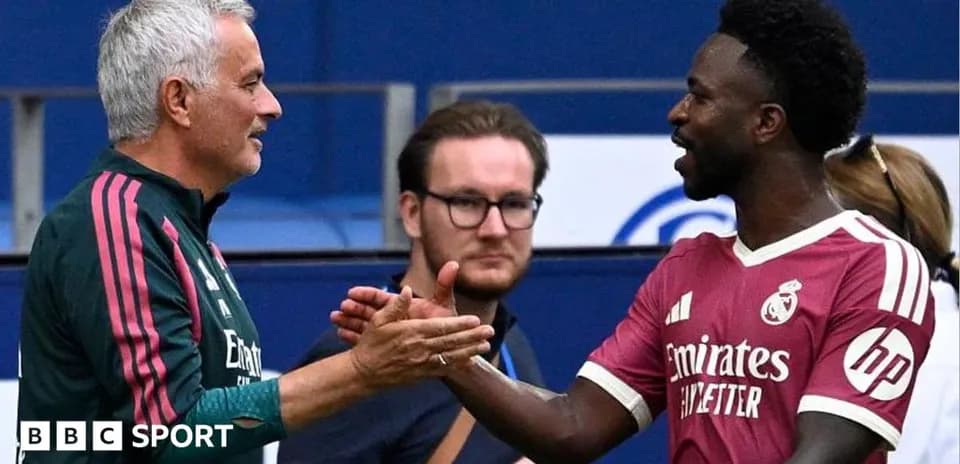 Two men shaking hands on football field