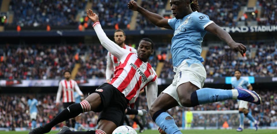 Player sliding to tackle during Manchester City match