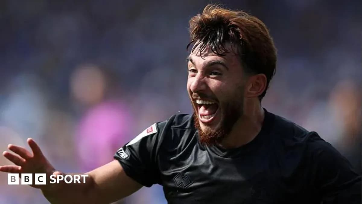 Futbolçu sevinclə qollarını qaldırır