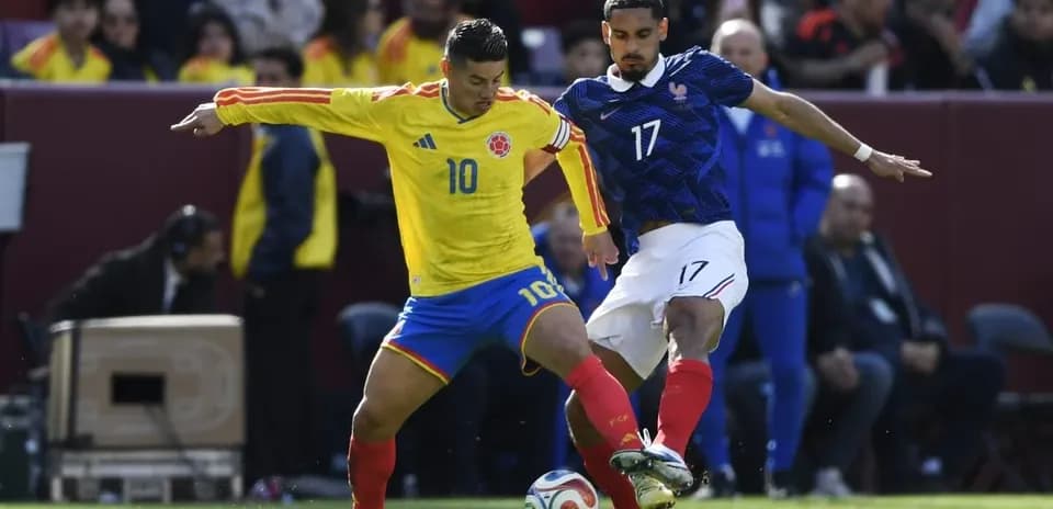 Colombian player dribbling past French opponent