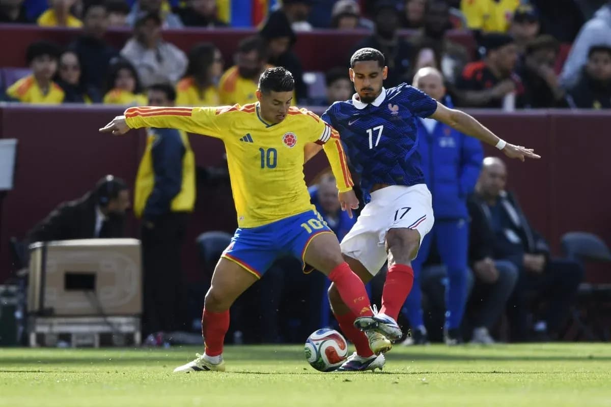 Colombian player dribbling past French opponent