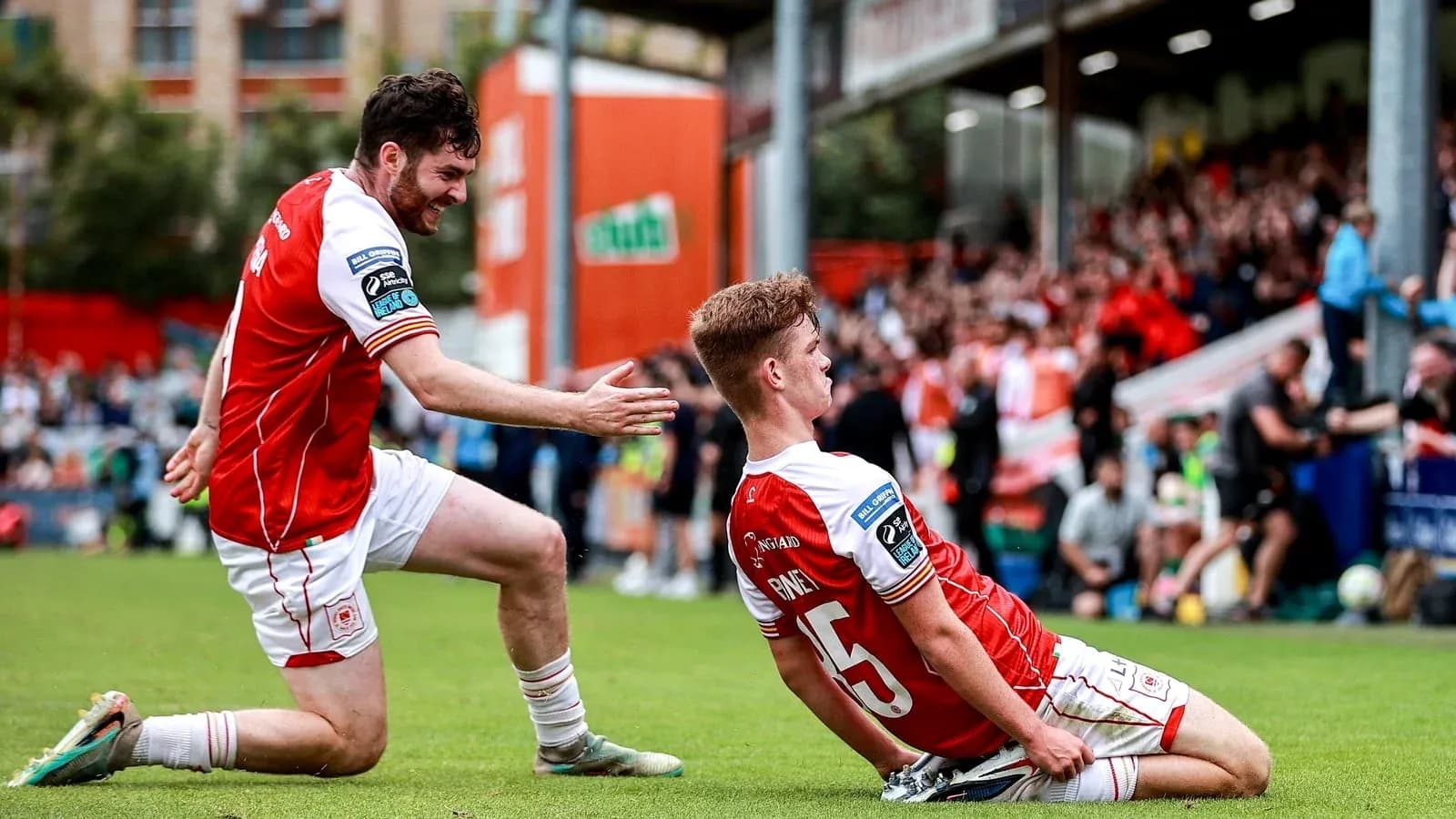 Two players celebrating a goal on the pitch