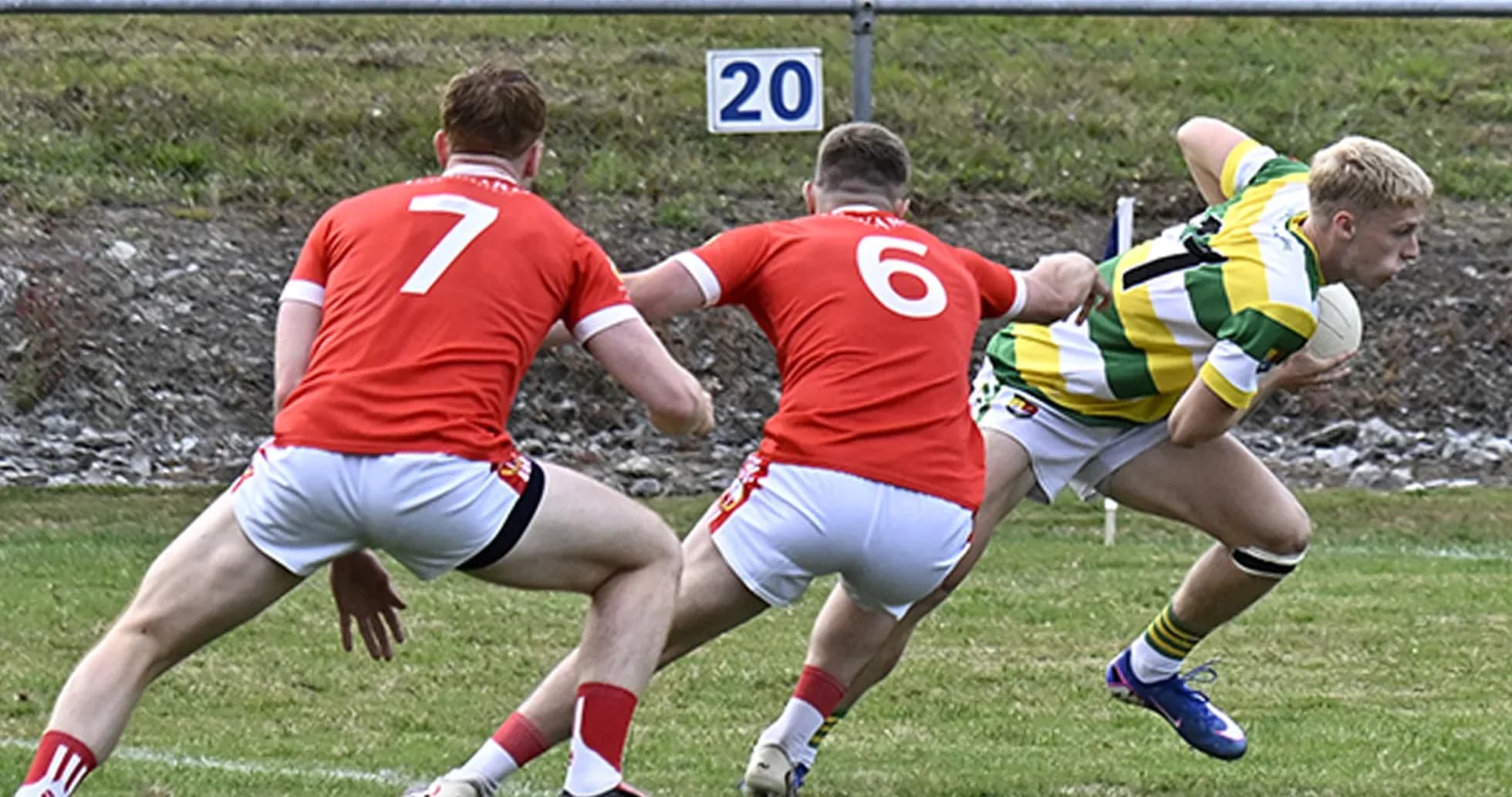 Player in green and yellow jersey evading two opponents