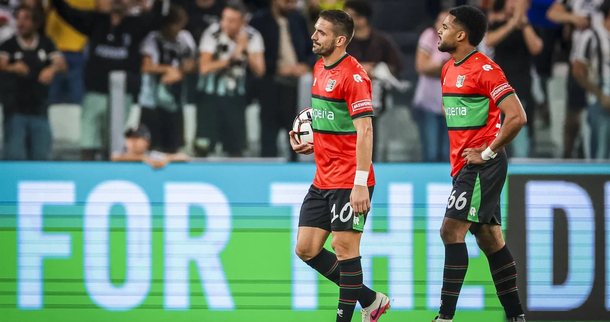 İki futbolçu meydanda top ilə yürüyür