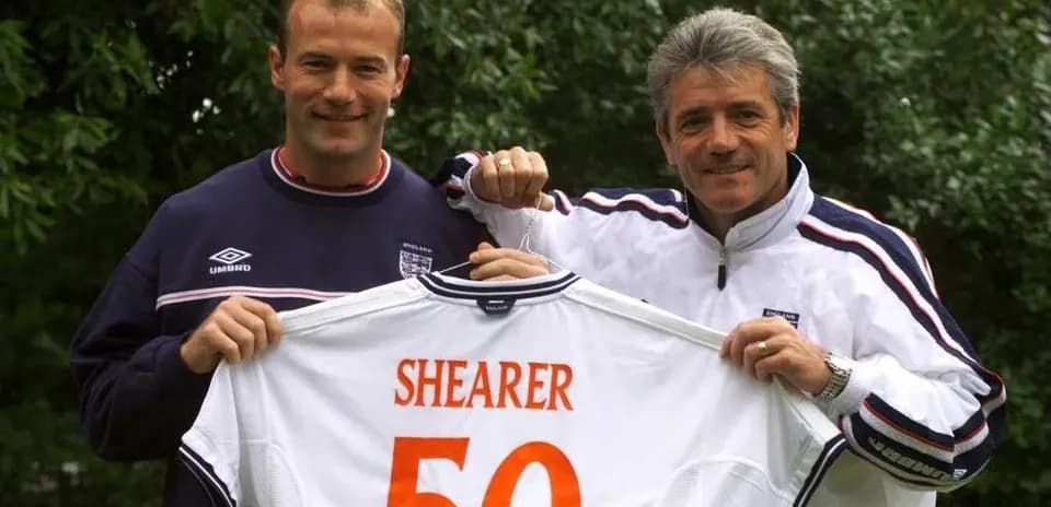 Two men holding England jersey with 'SHEARER 50'