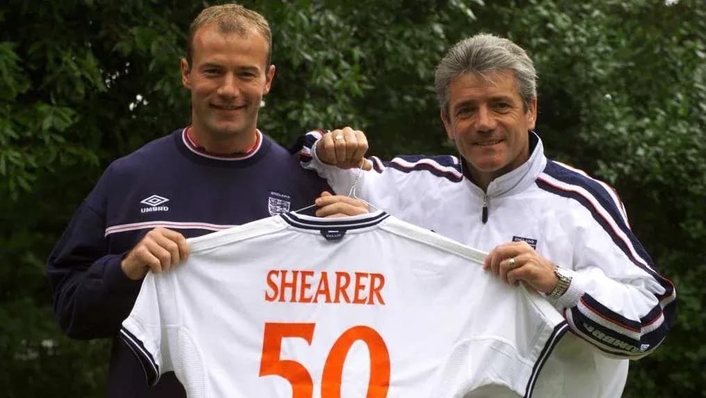 Two men holding England jersey with 'SHEARER 50'