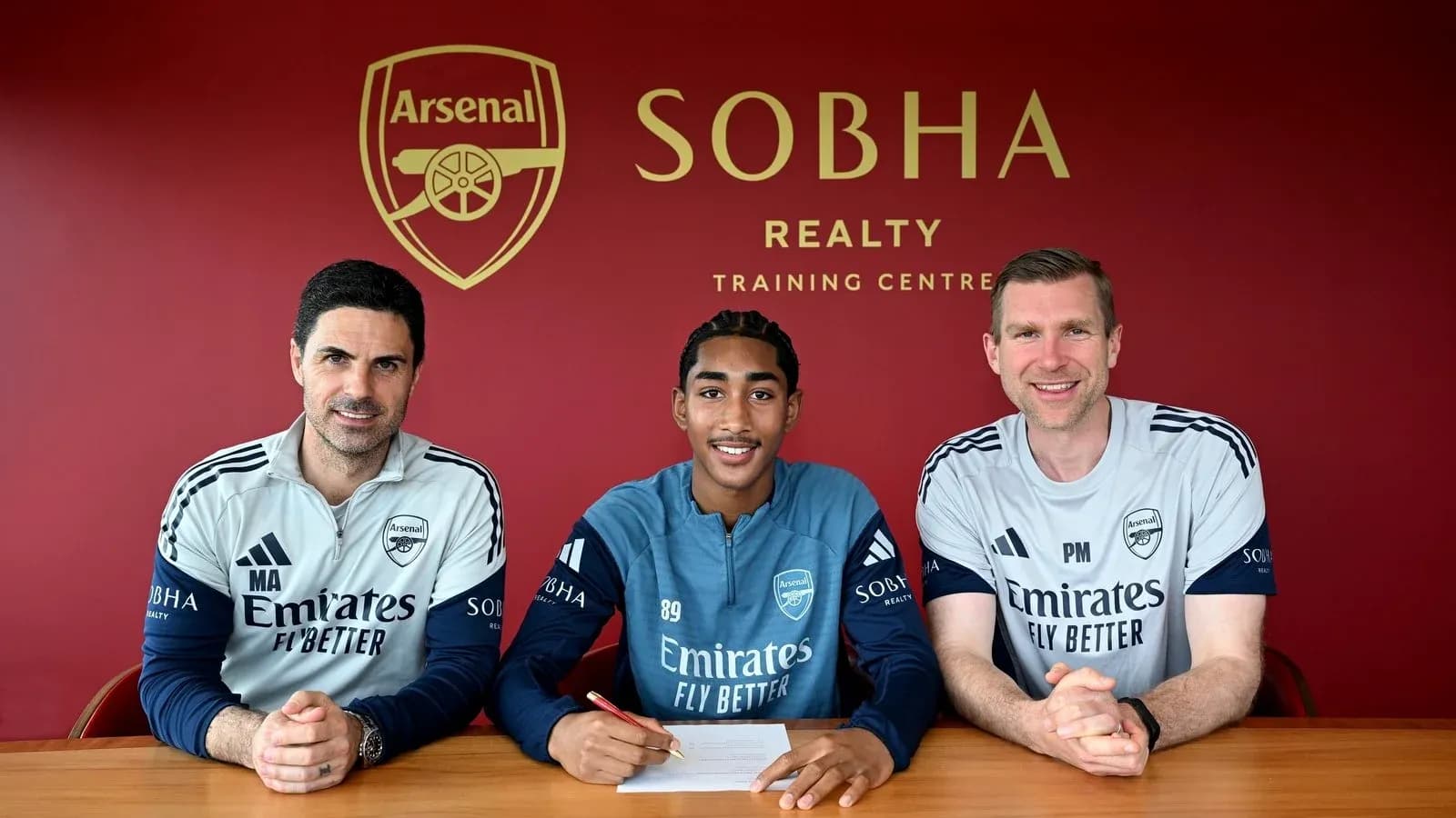 New player signing with Arsenal coaches at training center