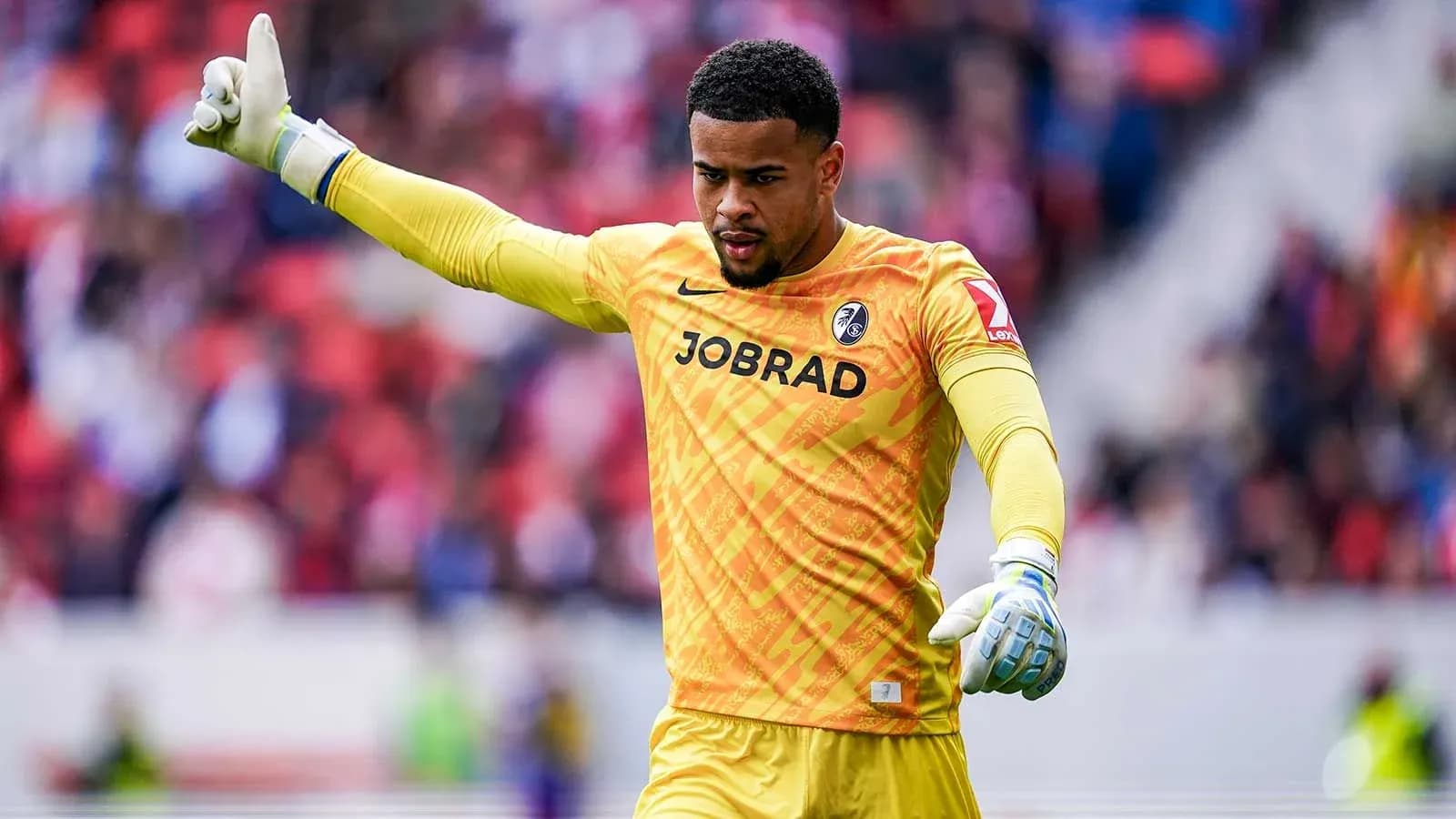 Goalkeeper signaling during a match in yellow kit