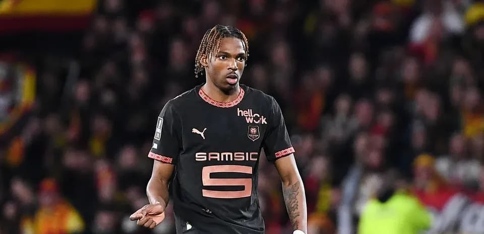 Futbolçu oyunda hərəkət edir, arxa planda azarkeşlər