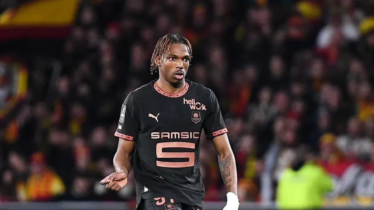 Futbolçu oyunda hərəkət edir, arxa planda azarkeşlər