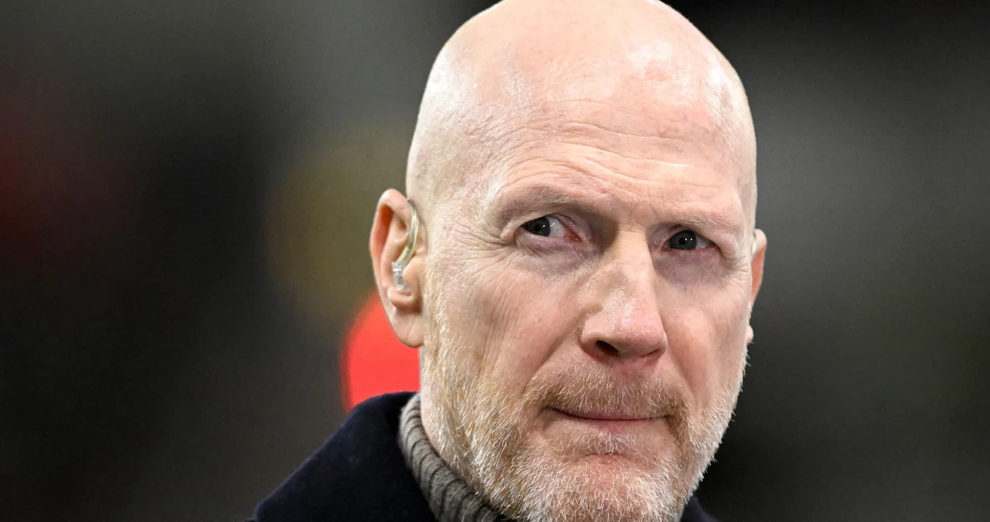 Bald man with earpiece at sports event