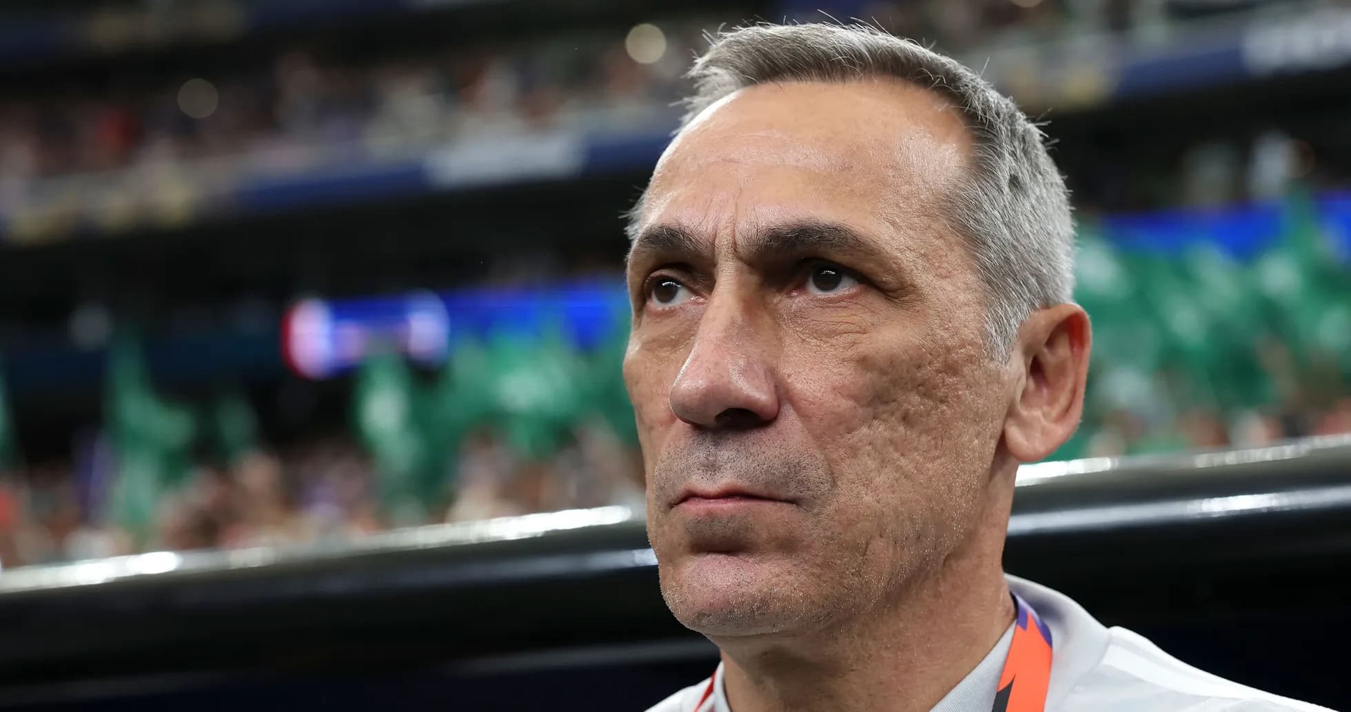 Coach focused during match with fans in background
