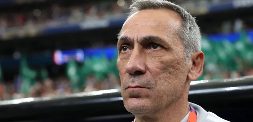 Coach focused during match with fans in background