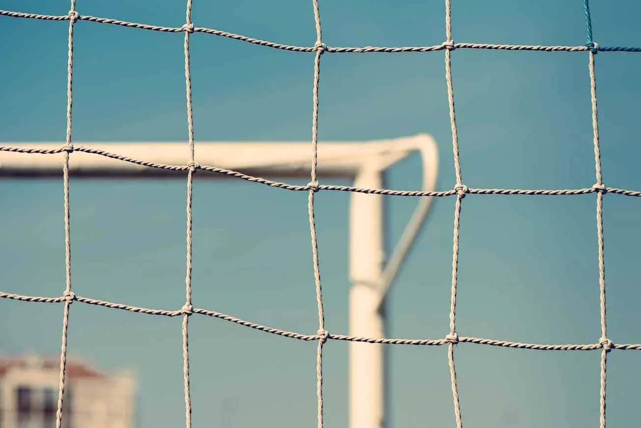 Football goal net against blue sky background